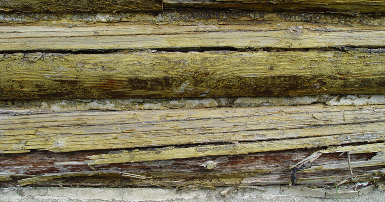 Log home exterior before restoration.